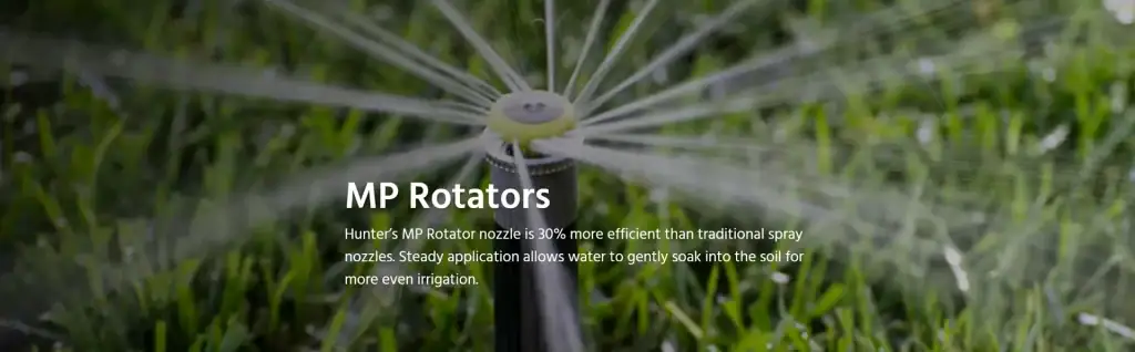 Close-up of an MP Rotator irrigation nozzle spraying water in a garden setting.